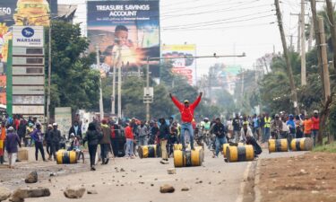 A demonstrator stands on a barricade cylinder during clashes with riot police in Nairobi on July 7.