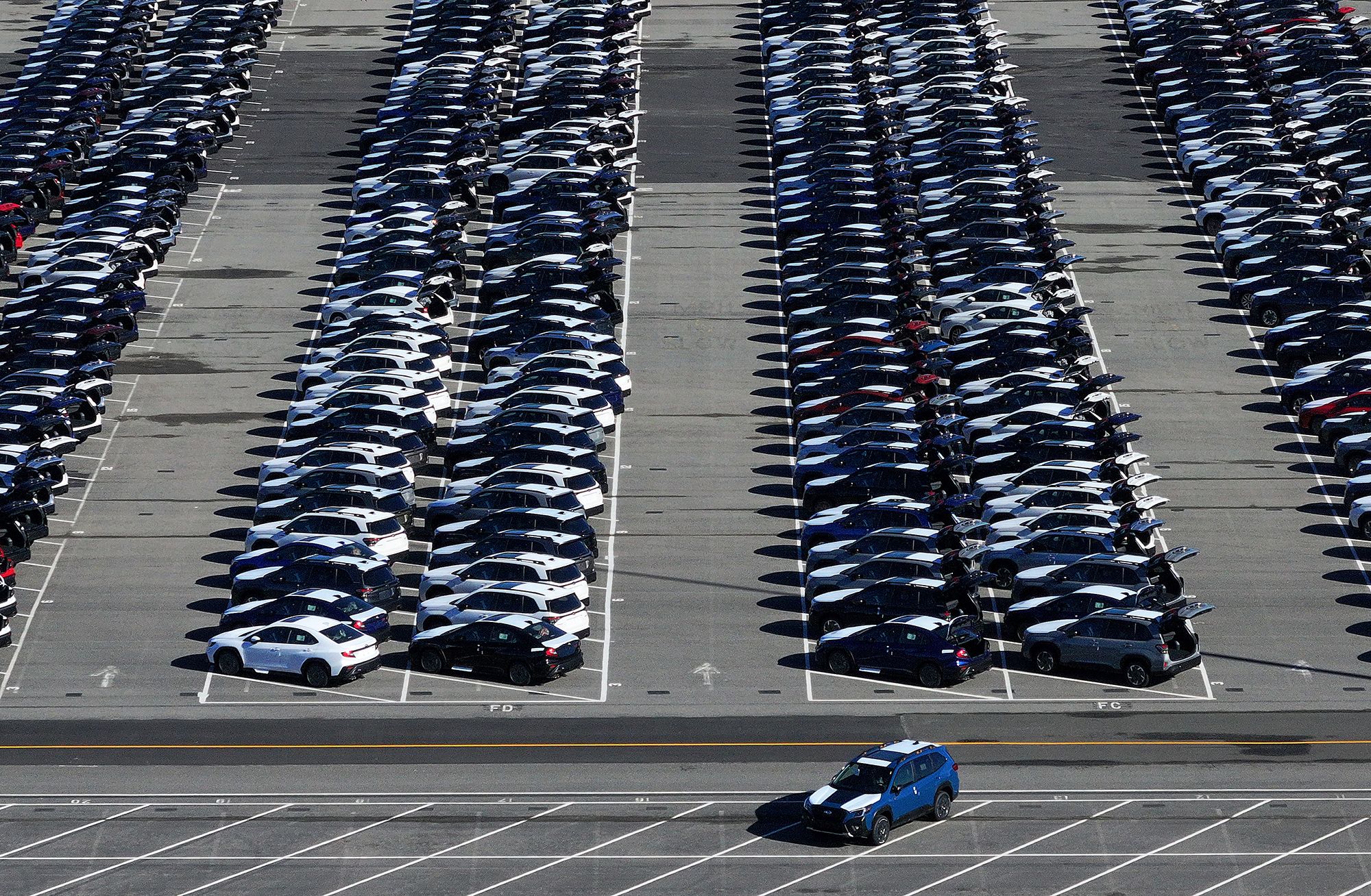 Brand new Subaru cars sit in a storage lot on March 24