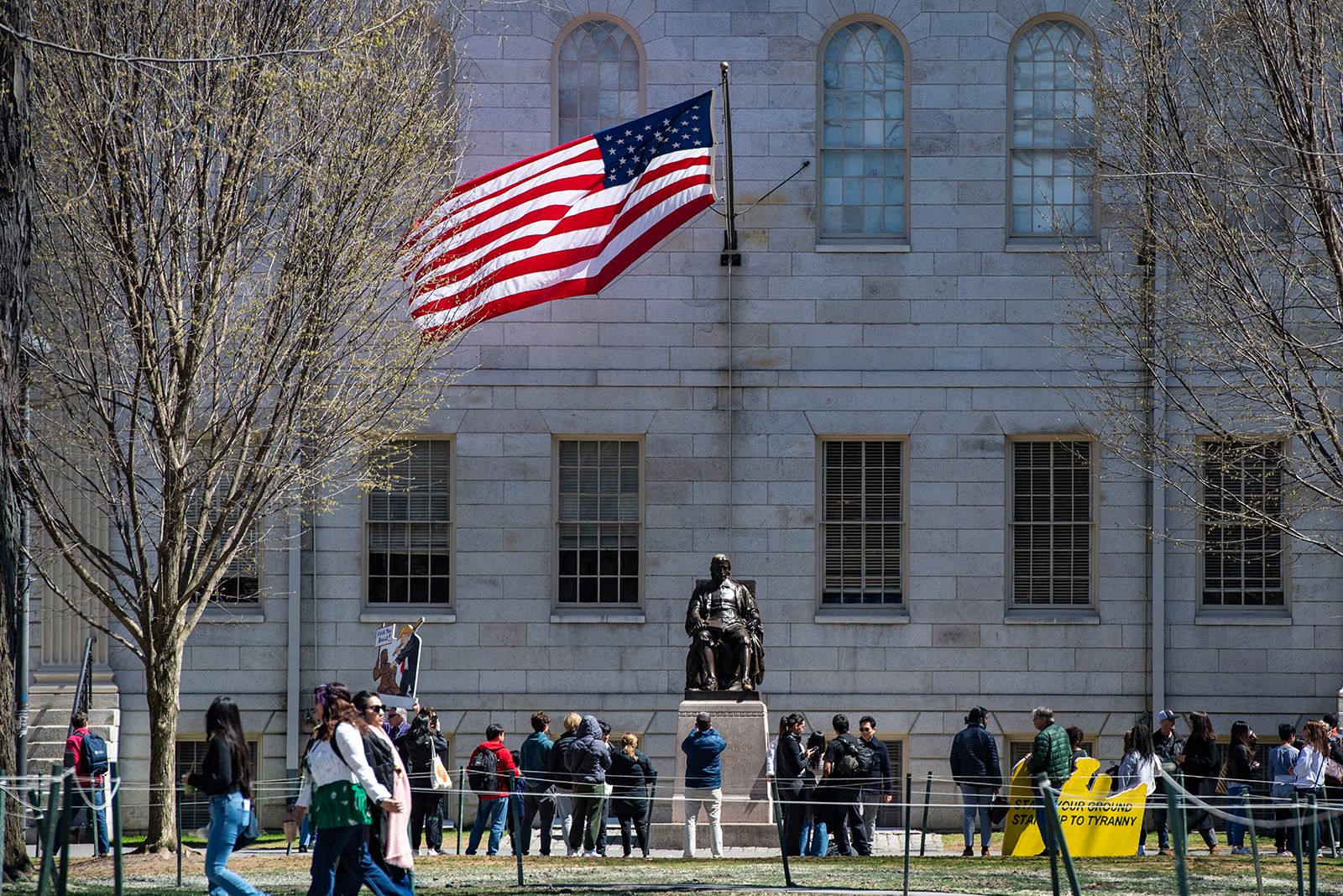 <i>Joseph Prezioso/AFP/Getty Images via CNN Newsource</i><br/>Demonstrators with signs stand around the John Harvard Statue in Harvard Yard after a rally was held against President Donald Trump's attacks on Harvard University at Harvard University in Cambridge