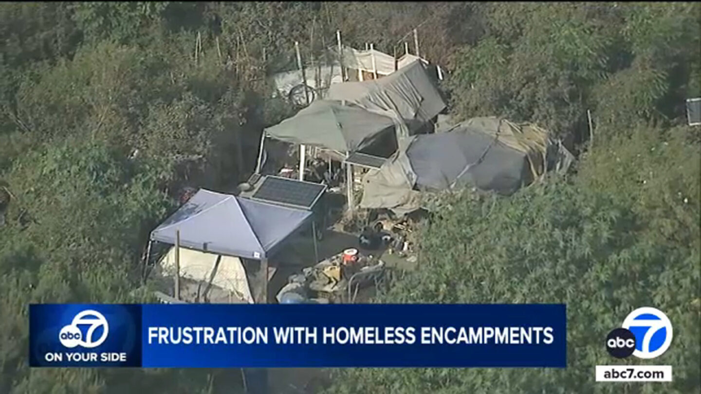 <i>KABC via CNN Newsource</i><br/>The encampment is not very visible from the ground but an aerial view from AIR7 shows a number of tents hidden in the bushes. It's located just south of the 60 Freeway and near the busy Shops at Montebello.