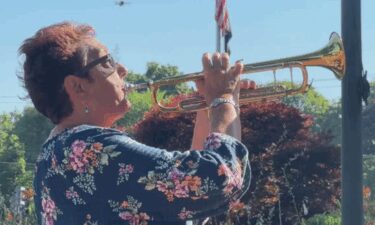 Jenn Hozempa plays her trumpet at the town common in Franklin