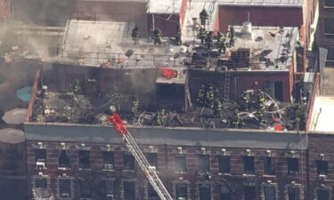 Firefighters battle a blaze on the roof of a building on East 95th Street on August 15.