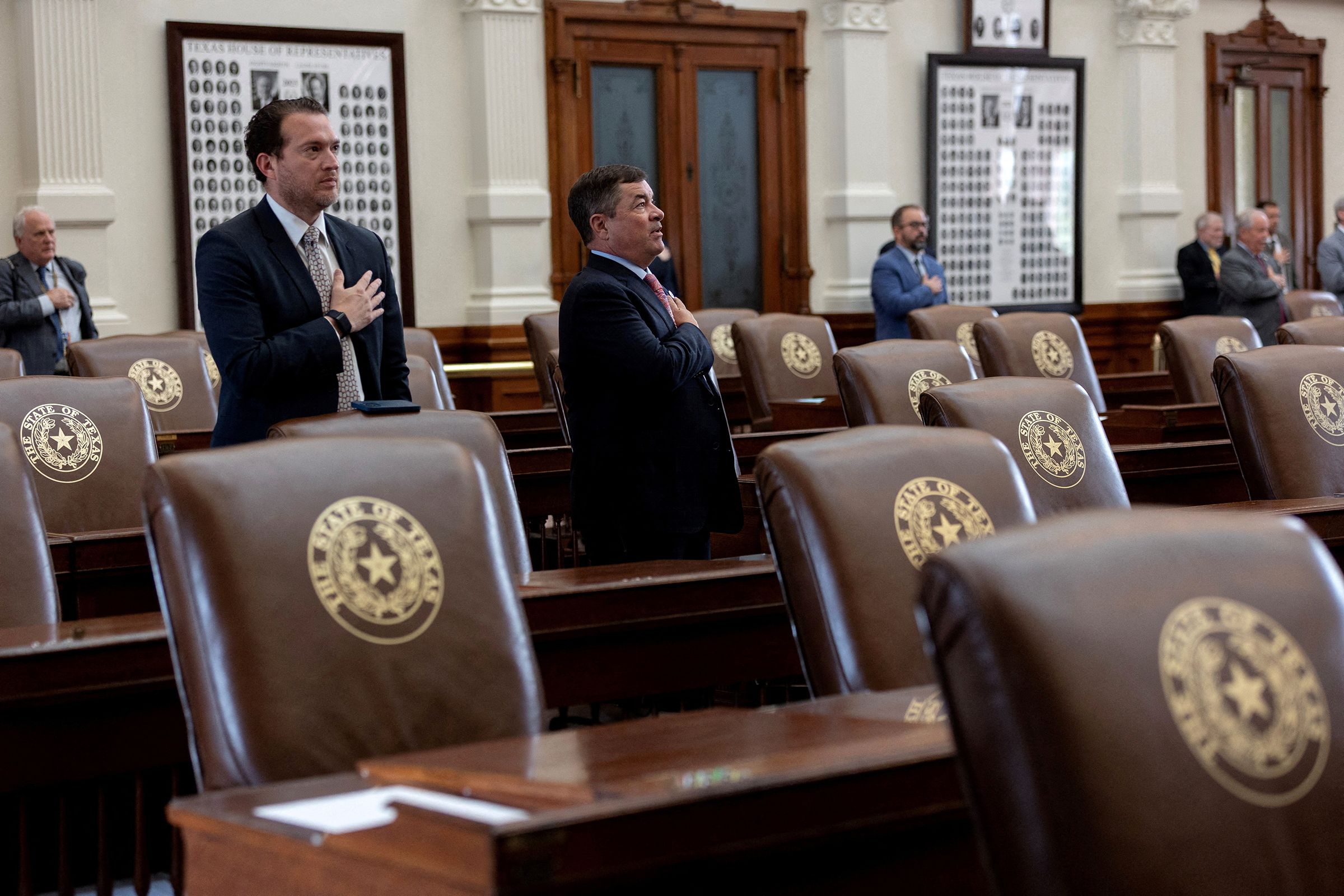 Surrounded by empty seats, Texas lawmakers say the pledge as the House is called to order after Democratic lawmakers in Texas left the state to deny Republicans the quorum needed to redraw the state's 38 congressional districts, at the Texas State Capitol in Austin, Texas, on August 4.