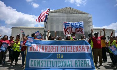 People hold a banner as they participate in a protest outside the US Supreme Court over President Donald Trump's move to end birthright citizenship.