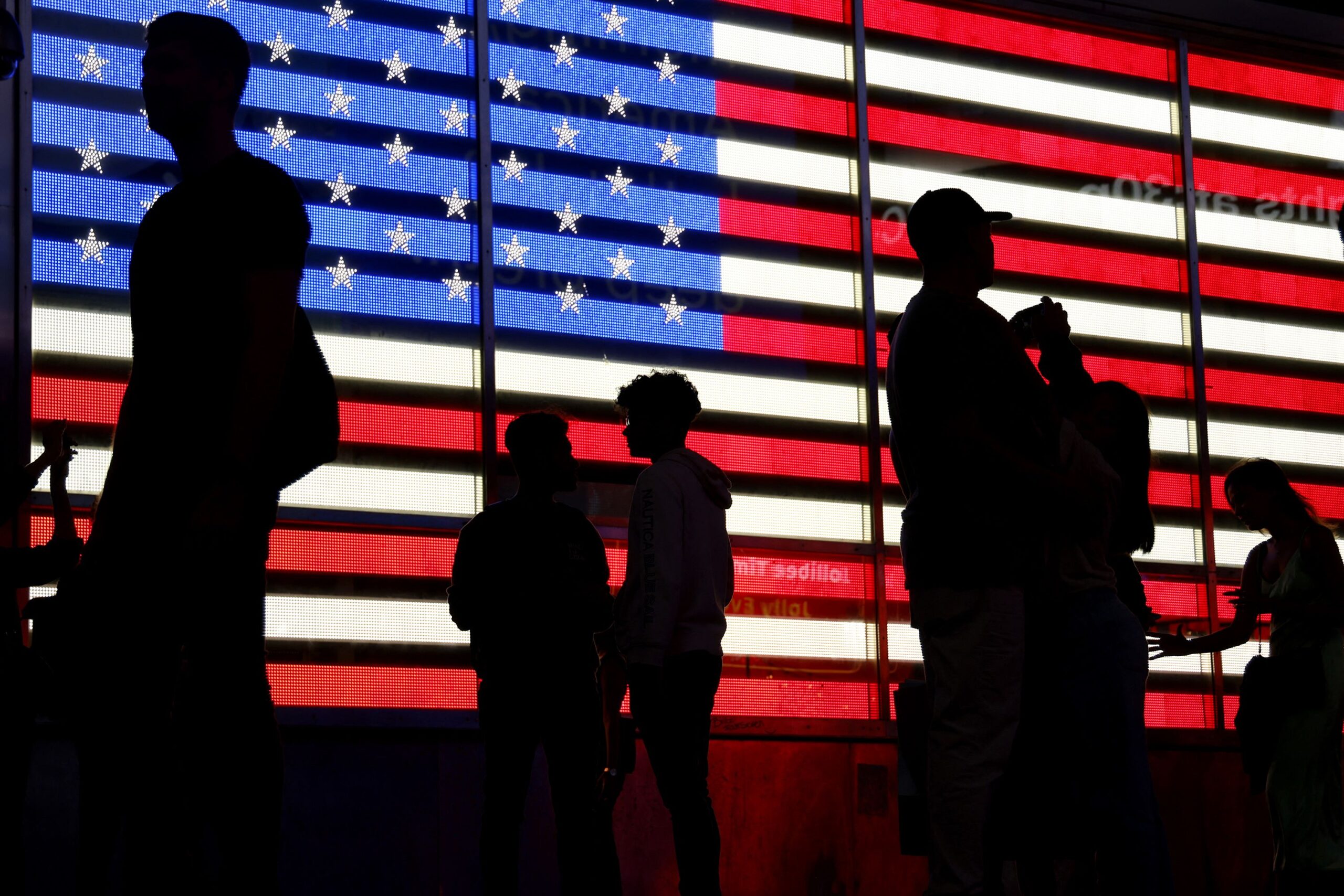 <i>Ludovic Marin/AFP/Getty Images via CNN Newsource</i><br/>People stand in front of a US flag on a screen in Times Square in New York on September 19