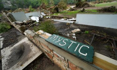 A Camp Mystic sign is seen along the banks of the Guadalupe River in Hunt