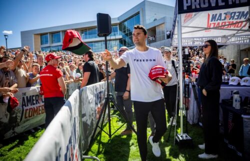 A police officer walks in front of a tent bearing the slogan 'The American Comeback Tour'
