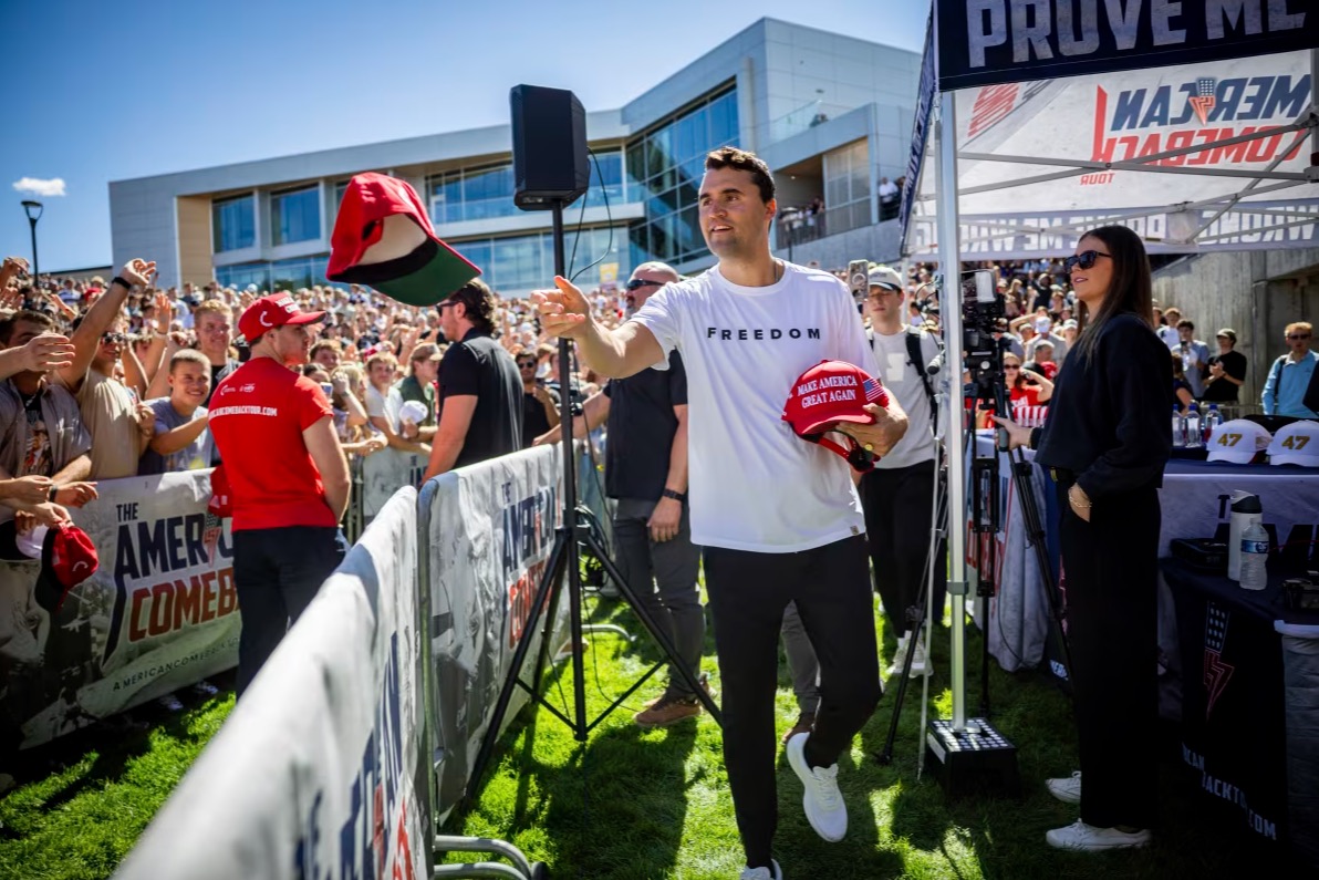 A police officer walks in front of a tent bearing the slogan 'The American Comeback Tour'