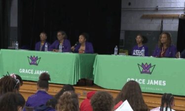 A purple lab coat is a symbol for the students at Grace M. James Academy