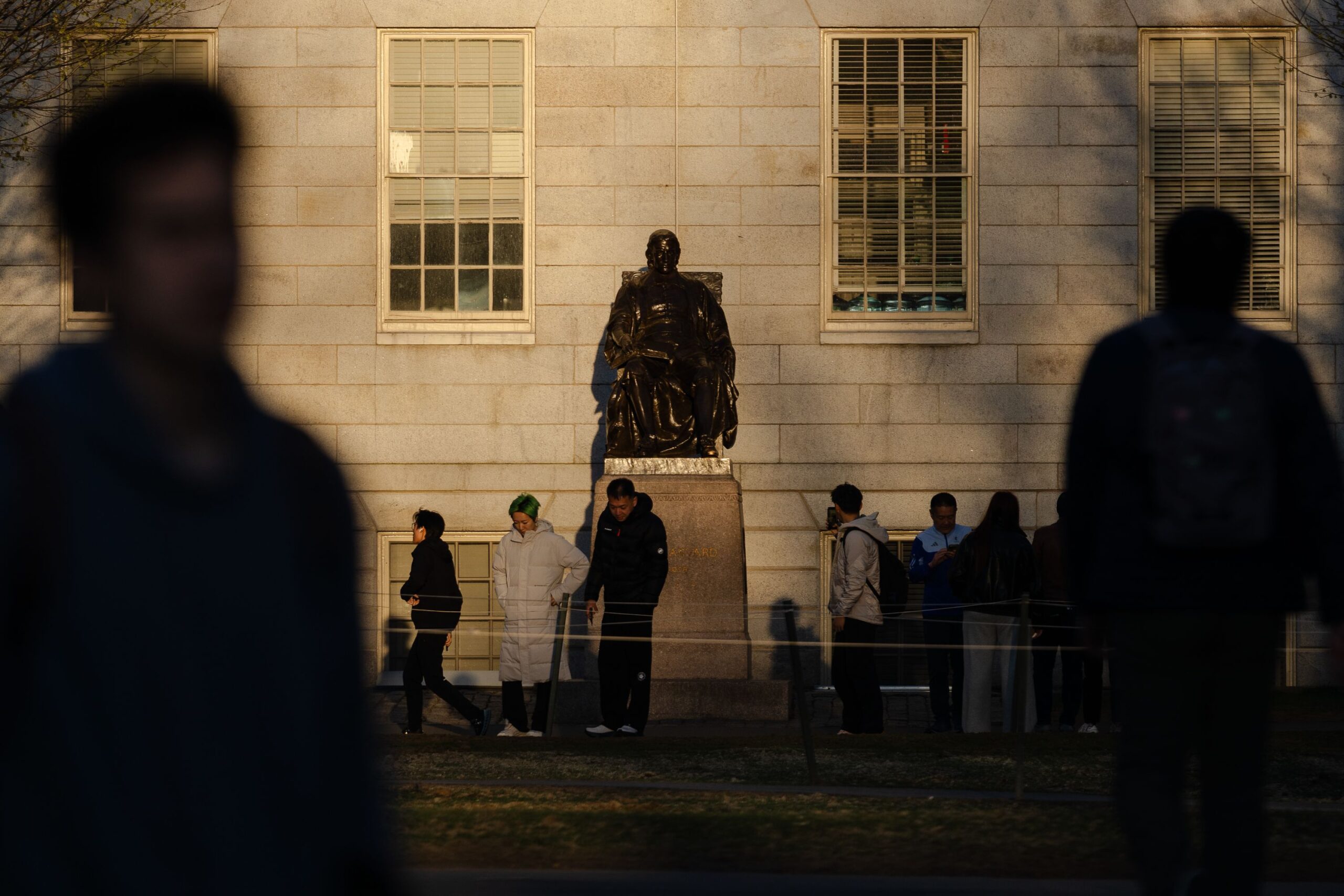 <i>Sophie Park/Getty Images via CNN Newsource</i><br/>People gather to take photos with the John Harvard Statue at Harvard University in Cambridge