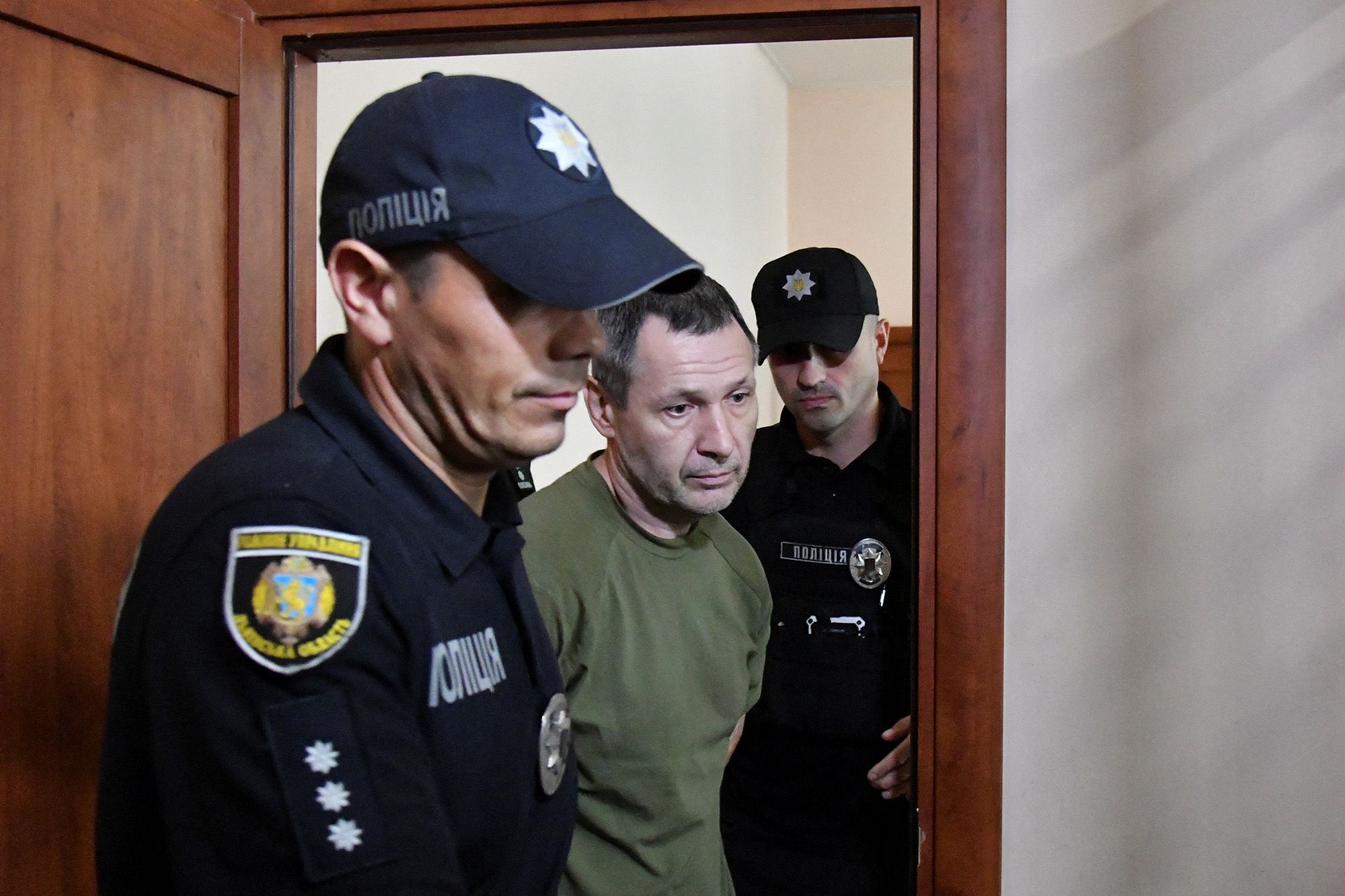 <i>Reuters via CNN Newsource</i><br/>Police officers escort the suspect in the murder of Ukrainian lawmaker Andriy Parubiy into a courtroom in Lviv