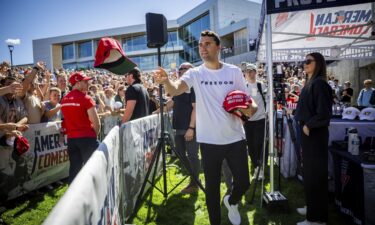 Charlie Kirk hands out hats before speaking at Utah Valley University on September 10.