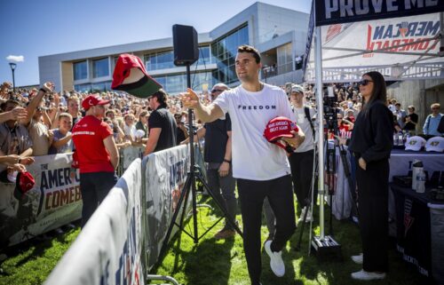 Charlie Kirk hands out hats before speaking at Utah Valley University on September 10.
