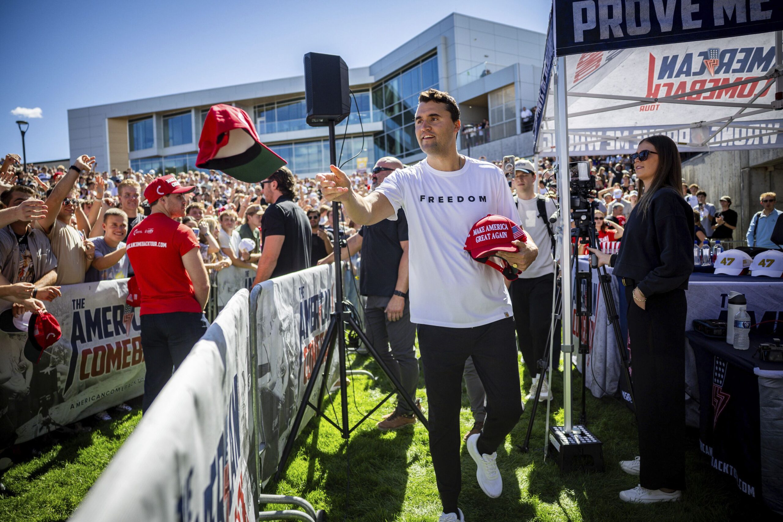 Charlie Kirk hands out hats before speaking at Utah Valley University on September 10.
