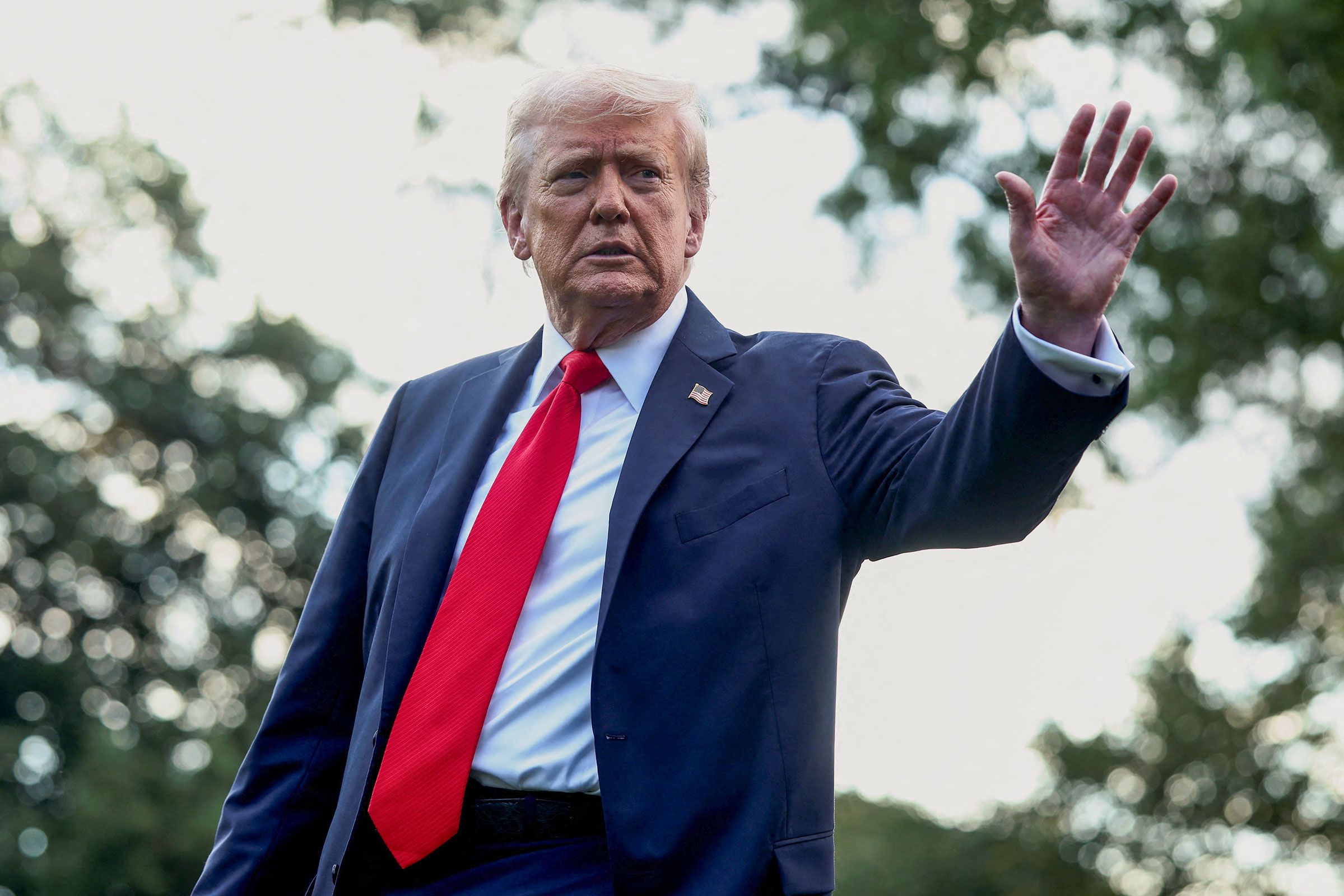 President Donald Trump waves to the media before boarding Marine One in Washington