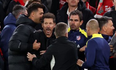 Diego Simeone is restrained as he confronts fans after Liverpool scores a late winner.
