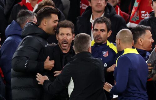 Diego Simeone is restrained as he confronts fans after Liverpool scores a late winner.