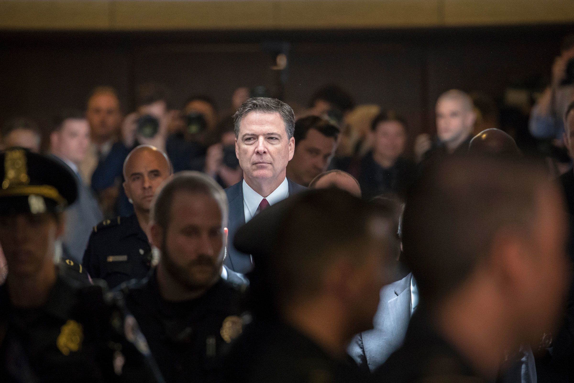 Former FBI director James Comey walks through a corridor on the way to a secure room to continue his testimony to the Senate Select Committee on Intelligence