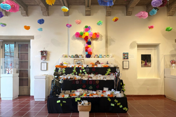 A community altar constructed by textile artist Genevieve Guadalupe stands in the art gallery of the nonprofit Tohono Chul botanical gardens in Tucson, Arizona, on Oct. 11, 2025. The altar holds cards where visitors write the names of departed loved ones and leave messages.