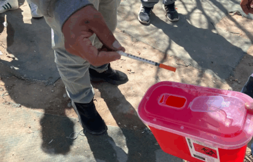 At the picadero along the train track, Montelongo and Rojas accept used syringes and hand out new ones. The man with the gray sweatshirt is Erick.