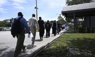 Job seekers walk in line to a job fair at the Central Florida Fairgrounds attended by employers looking to fill openings on July 10 in Orlando.
