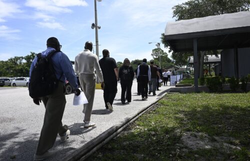 Job seekers walk in line to a job fair at the Central Florida Fairgrounds attended by employers looking to fill openings on July 10 in Orlando.