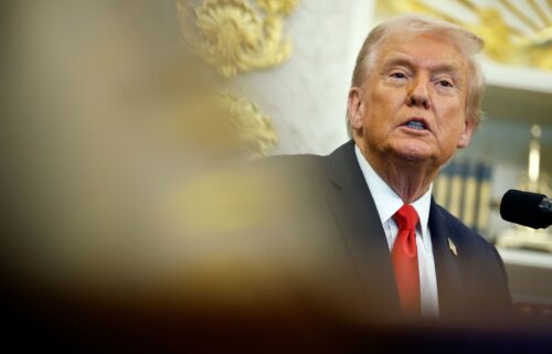 President Donald Trump answers questions from reporters in the Oval Office of the White House on Thursday.