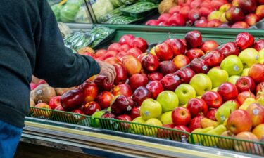 A shopper looks at produce at a grocery store in West Milton