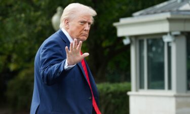 US President Donald Trump waves as he arrives at the White House