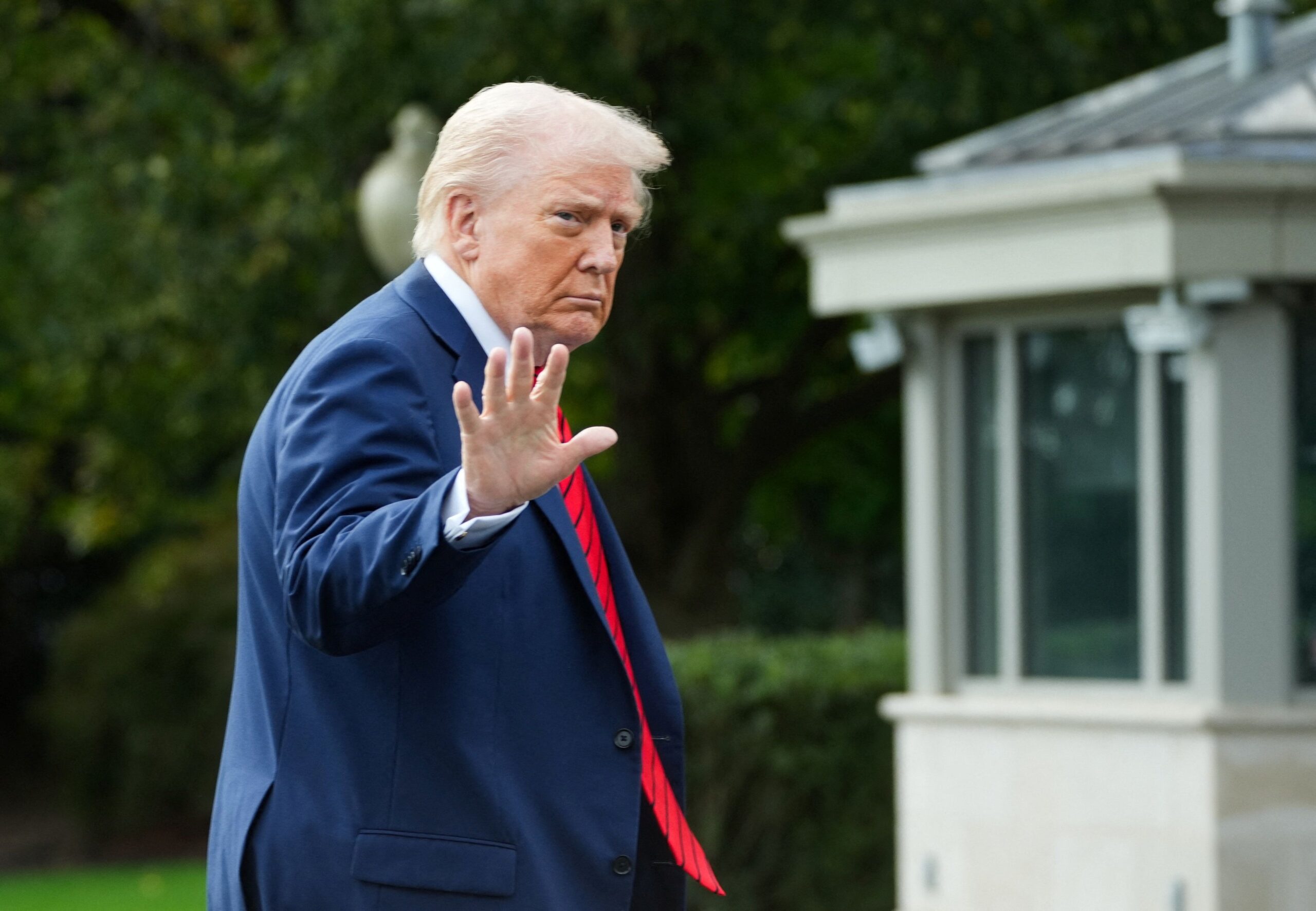 US President Donald Trump waves as he arrives at the White House