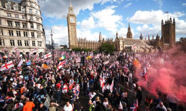 Anti-immigration protesters wave British and England flags during the "Unite The Kingdom" rally in London on September 13