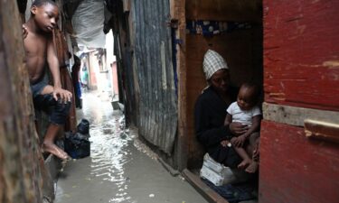A woman looks out from inside a house in Alligator Pond