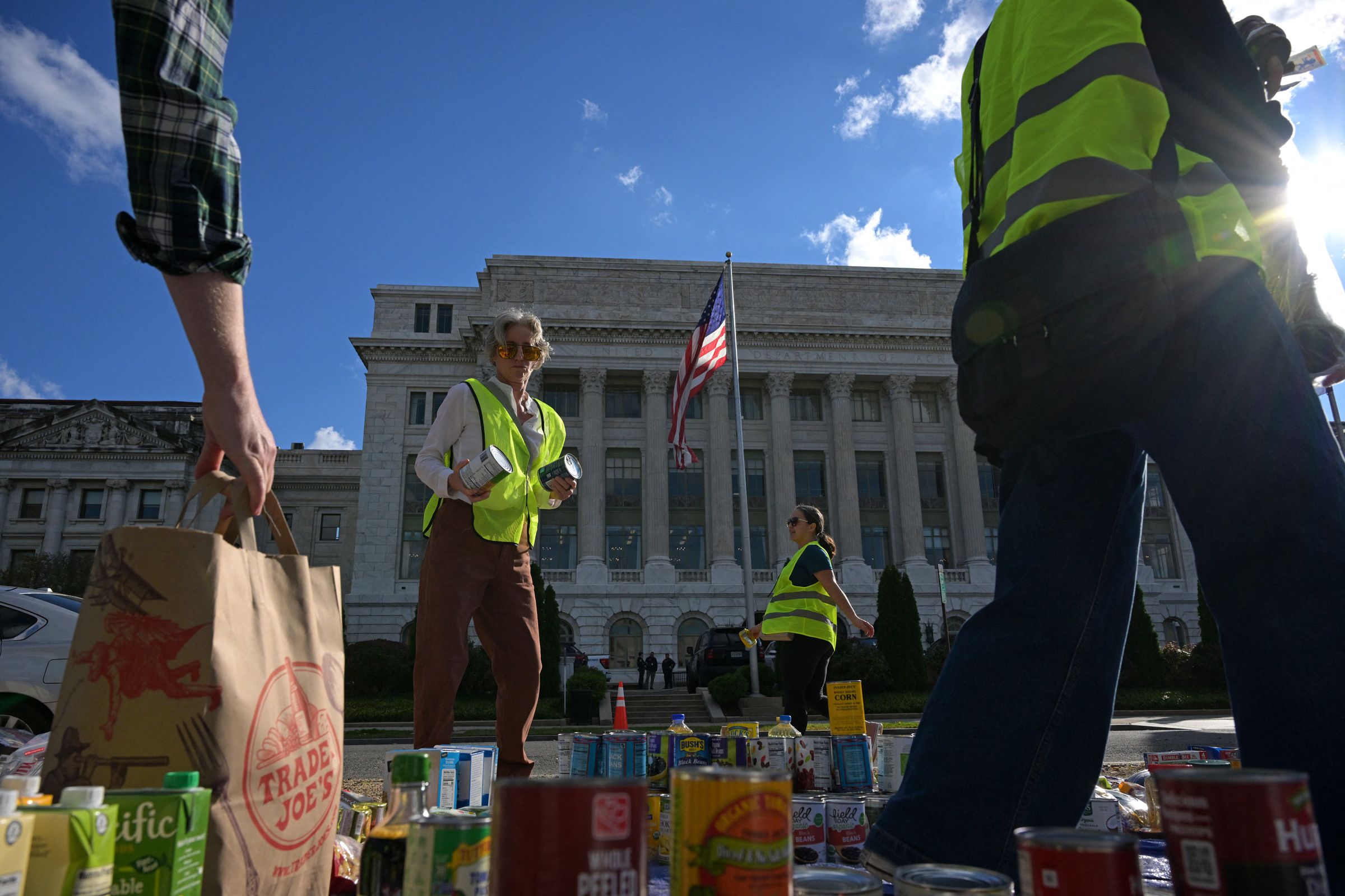 Furlogh federal workers and volunteers collect groceries during the People's Pantry Food drive to replenish food banks ahead of SNAP lapse at the USDA Headquarters