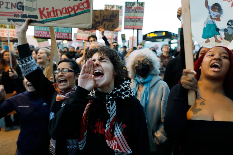 People shout slogans while protesting the arrival of the Texas National Guard and US Immigration and Customs Enforcement agents during a demonstration in downtown Chicago, Illinois, on October 8, 2025. Chicago, the third-largest in the country, has become the latest flashpoint in a crackdown by US Immigration and Customs Enforcement (ICE) agents that has sparked allegations of rights abuses and myriad lawsuits.