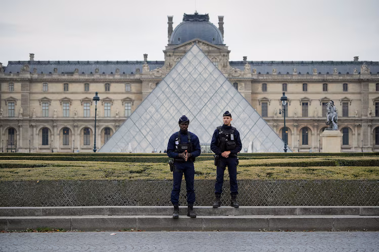 Police stand guard outside the Louvre museum at Louvre, October 19, 2025, in Paris, France.