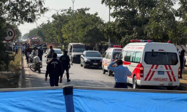 Police officers and ambulances attend the scene after a blast outside a court building in Islamabad