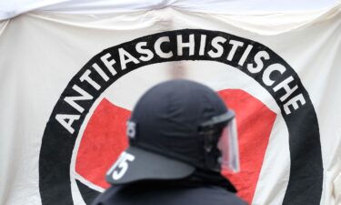 A policeman stands in front of an Antifa banner during a left-wing demonstration in Thuringia
