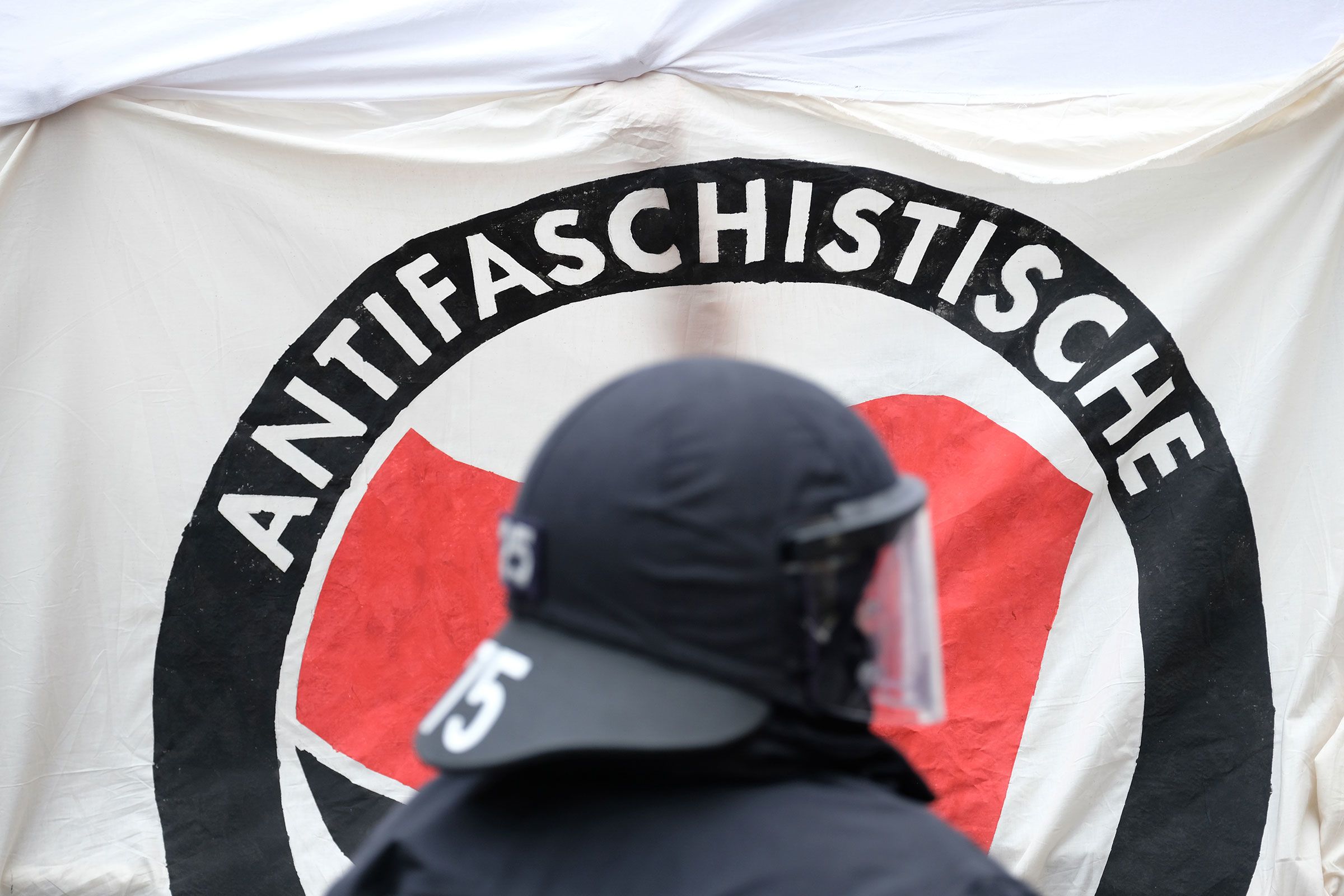 <i>Sebastian Willnow/Picture Alliance/Getty Images/File via CNN Newsource</i><br/>A policeman stands in front of an Antifa banner during a left-wing demonstration in Thuringia