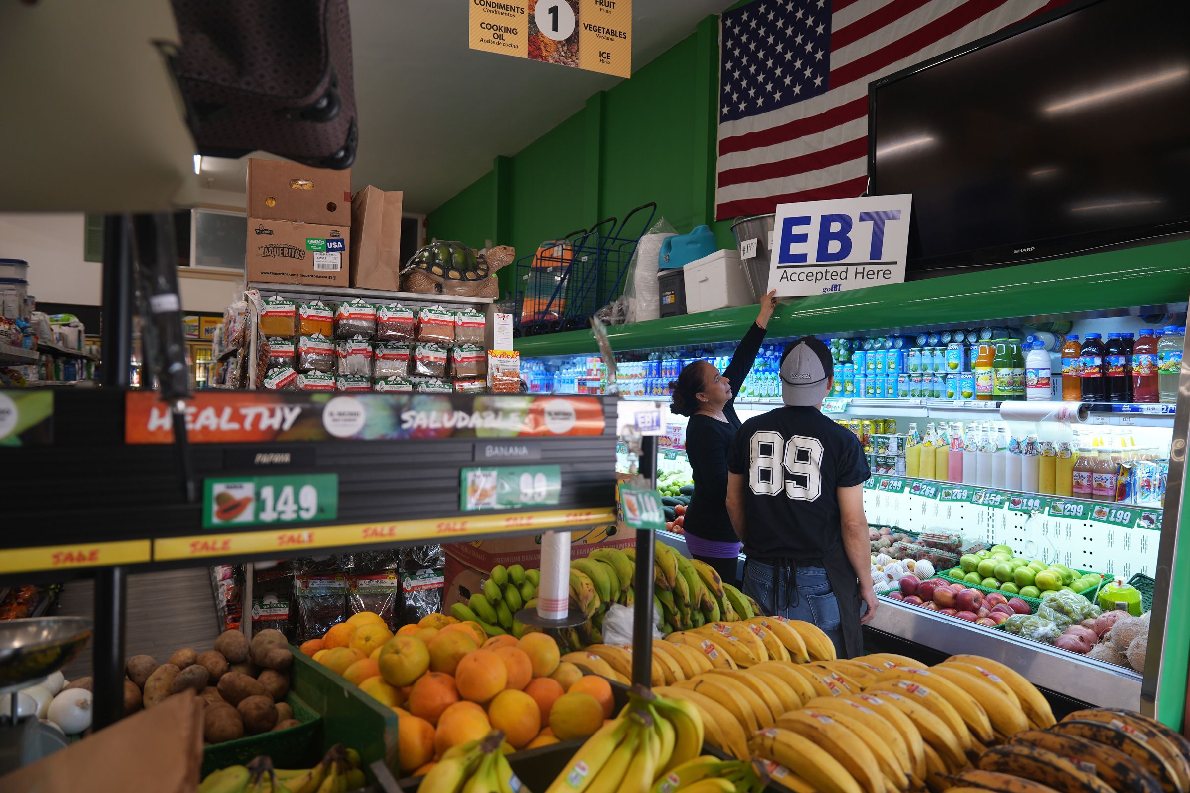 <i>Damian Dovarganes/AP via CNN Newsource</i><br/>El Recuerdo Market manager Cecilia Benitez sets up a "EBT Accepted Here