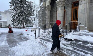A man shovels snow outside a church in Lowville