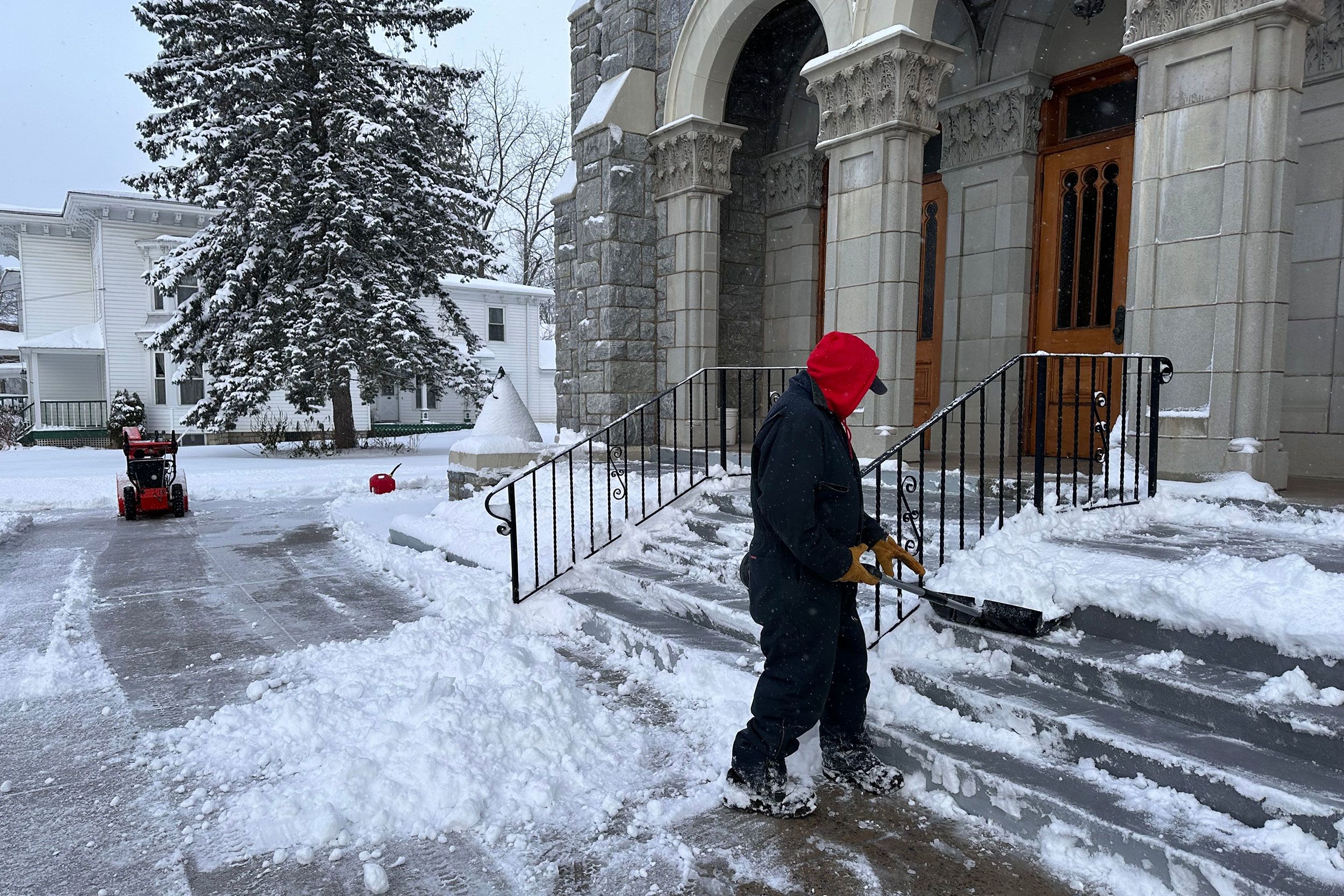 <i>Cara Anna/AP via CNN Newsource</i><br/>A man shovels snow outside a church in Lowville