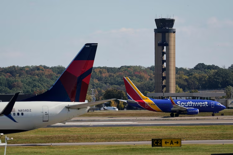 Planes taxi past the control tower before takeoff at the Nashville International Airport, Friday, Oct. 31, 2025, in Nashville, Tenn.