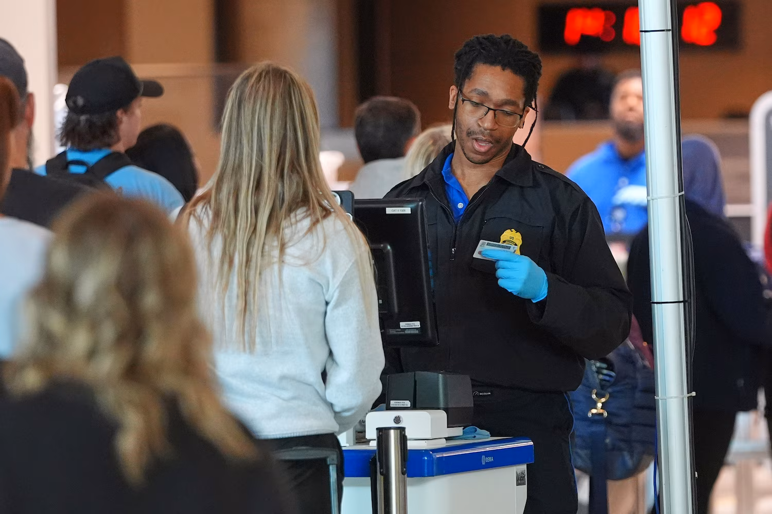 A TSA agent checks a traveler's identification at Dallas Love Field Airport, Nov. 11, 2025, in Dallas.