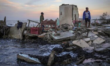 Researchers say individuals will often bear the economic burden of climate change. Yahir Mayoral and Emily Camacho walk amid the rubble of their grandmother's home