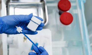 A gynecologist holds a flask for a Pap test