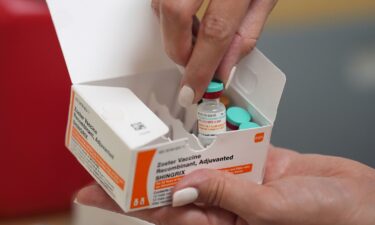 A pharmacist displays doses of a vaccine that protects against shingles