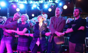 Revellers sing link arms while singing "Auld Lang Syne."