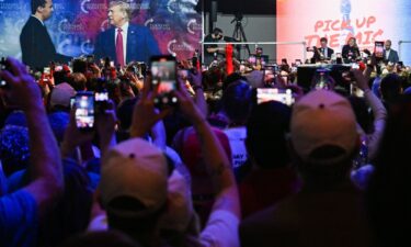 An attendee looks on as Erika Kirk speaks during Turning Point USA's AmericaFest 2025 in Phoenix on December 19