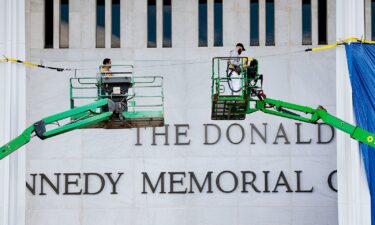 Workers adjust the name of the “John F. Kennedy Memorial Center for the Performing Arts" on December 19