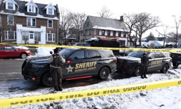 Members of the Hennepin County Sheriff's Office look on as people gather near the scene of a suspected shooting by an ICE agent during federal law enforcement operations on Wednesday in Minneapolis.